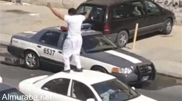 "فيديو" مخمور يرقص فوق سيارة بأحد شوارع الكويت ويعتدي على رجل أمن 1