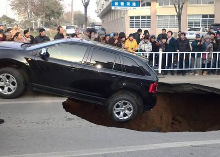 "بالصور" سيارة تنجو بأعجوبة من السقوط بحفرة في أحد شوارع الصين 3