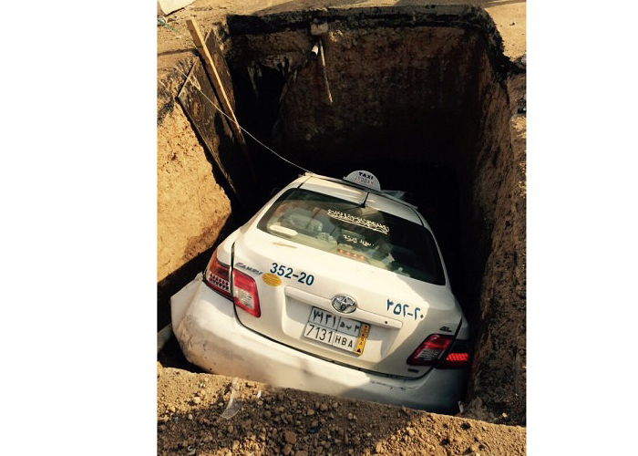 “بالصور” سيارة اجرة تسقط في حفرة وسط طريق في مدينة جدة